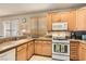 Bright kitchen featuring light wood cabinets, granite countertops and stainless steel appliances at 9844 Altadena St, Las Vegas, NV 89183