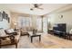 Bright living room with neutral walls, travertine floors, a ceiling fan, and access to the backyard at 9844 Altadena St, Las Vegas, NV 89183