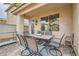 Charming outdoor patio area with stone pavers, six chairs, and a table at 9844 Altadena St, Las Vegas, NV 89183