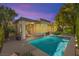 Backyard view featuring swimming pool, covered patio, outdoor kitchen, trees, and beautiful outdoor lighting at 10404 Longwood Dr, Las Vegas, NV 89134