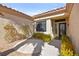Welcoming courtyard entrance with decorative plants and shrubs, leading to a stylish front door with an ornate design at 10404 Longwood Dr, Las Vegas, NV 89134