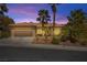 Charming single-story home with desert landscaping and a two-car garage, accentuated by mature palm trees at 10404 Longwood Dr, Las Vegas, NV 89134
