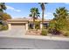 Charming single-story home with desert landscaping and a two-car garage, accentuated by mature palm trees at 10404 Longwood Dr, Las Vegas, NV 89134