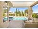 Backyard swimming pool with covered patio and tall privacy trees providing lots of shade and seclusion at 10404 Longwood Dr, Las Vegas, NV 89134