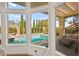 View of the backyard pool and patio area, seen through large windows, offers a peaceful oasis at 10404 Longwood Dr, Las Vegas, NV 89134