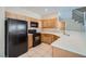 Well-lit kitchen featuring wooden cabinets, black appliances, and tiled backsplash at 1142 Heavenly Harvest Pl # 2, Henderson, NV 89002