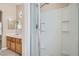 Shower stall features white tiling and shelves next to vanity and large mirror at 1142 Heavenly Harvest Pl # 2, Henderson, NV 89002