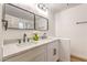 Modern bathroom featuring double sinks, quartz countertops, dark hardware, and a decorative vase at 1183 Winnipeg Ct, Henderson, NV 89002