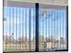 View through the home's bars in the window to the neighborhood streets outside at 1701 E Katie Ave # 21, Las Vegas, NV 89119