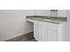 Bathroom vanity with stone countertop, white cabinets, and wood-look flooring at 1709 Desert Path Ave, North Las Vegas, NV 89032