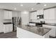 Modern kitchen with stainless steel appliances, white cabinets, an island and stone countertops at 1709 Desert Path Ave, North Las Vegas, NV 89032
