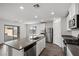 Bright open kitchen with stainless appliances, gray stone countertops, and sliding door access to patio at 1709 Desert Path Ave, North Las Vegas, NV 89032