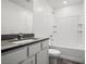 Bathroom with a shower-tub combo, white tile surround, and a stone countertop vanity at 1709 Desert Path Ave, North Las Vegas, NV 89032