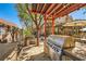 Covered outdoor kitchen with stainless steel grill, custom countertops, and ample prep space at 1801 Glory Creek Dr, Las Vegas, NV 89128