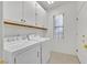 Bright laundry room with washer, dryer, storage cabinets and a window at 2084 Fort Halifax St, Henderson, NV 89052