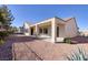 This backyard features a covered patio, perfect for outdoor living and entertaining, with gravel landscaping and a privacy wall at 2156 Twin Falls Dr, Henderson, NV 89044