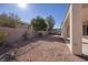 This backyard features a covered patio, perfect for outdoor living and entertaining, with gravel landscaping and a privacy wall at 2156 Twin Falls Dr, Henderson, NV 89044