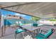 Inviting covered patio with a dining area, perfect for outdoor entertaining with view of pool and solar panels on house in backyard at 2302 Wagonwheel Ave, Las Vegas, NV 89119