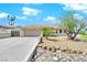 Single story home boasting desert landscaping, neutral tones, and a large two-car garage at 2302 Wagonwheel Ave, Las Vegas, NV 89119