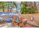 Charming backyard patio area with dining set, painted mural, and mature landscaping at 2700 Brienza Way, Las Vegas, NV 89117