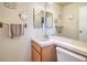 Simple bathroom with a oak vanity, white sink, and tiled countertop and floral decoration at 2700 Brienza Way, Las Vegas, NV 89117