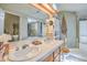 Bathroom with dual sinks, white tile counters, and a glass door shower and tub at 2700 Brienza Way, Las Vegas, NV 89117