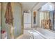 Bathroom featuring glass shower, marble tub, and vanity with mirror and cabinet at 2700 Brienza Way, Las Vegas, NV 89117