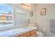 Bright bathroom with a tile countertop, large mirror, and a window with neighborhood views at 2700 Brienza Way, Las Vegas, NV 89117