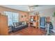 Bedroom with laminate floors, fan, sofa and large window with an office area and treadmill at 2700 Brienza Way, Las Vegas, NV 89117