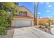 Charming two-story home boasts a tile roof, desert landscaping, and an attached two-car garage at 2700 Brienza Way, Las Vegas, NV 89117