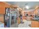 Well lit kitchen with stainless steel refrigerator, wooden cabinets, and white tiled floors at 2700 Brienza Way, Las Vegas, NV 89117