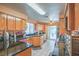 Well-lit kitchen with granite countertops, oak cabinets, a gas stove, and white tiled floors at 2700 Brienza Way, Las Vegas, NV 89117