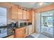 Kitchen with wooden cabinets and granite countertops leading to sliding glass doors and a pool at 2700 Brienza Way, Las Vegas, NV 89117