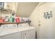 Well-equipped laundry room with washer, dryer, storage shelves, and a door to storage at 2700 Brienza Way, Las Vegas, NV 89117