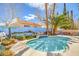 Inviting pool with blue tile trim, mural on back wall, lush landscaping, and sunny skies at 2700 Brienza Way, Las Vegas, NV 89117