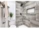 A remodeled bathroom offers gray tiling in the shower and a plant above the toilet at 2834 Natalie Ave, Las Vegas, NV 89121