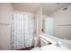Bright bathroom features laminate flooring, shower with seashell curtain and white vanity at 2969 Juniper Hills Blvd # 103, Las Vegas, NV 89142