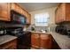 Functional kitchen features granite countertops, wood cabinets, and black appliances at 2969 Juniper Hills Blvd # 103, Las Vegas, NV 89142