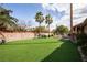 Backyard with mature landscaping and synthetic lawn at 3236 Cliff Sieler Ct, Las Vegas, NV 89117