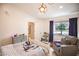 Bright bedroom with a white bed frame, wood laminate floors, and a view from the large window at 3236 Cliff Sieler Ct, Las Vegas, NV 89117