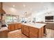 Open concept kitchen with an island, wood cabinets, stainless steel appliances, marble countertops, and wood laminate floors at 3236 Cliff Sieler Ct, Las Vegas, NV 89117