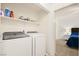 Bright laundry room featuring modern washer and dryer, with shelving for storage and doorway to bedroom at 354 Sunward Dr # 0, Henderson, NV 89014