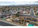 Wide aerial shot displaying a residential area with houses, streets, a pool, tidy yards, and striking mountains in the distance at 3572 Tempe St, Las Vegas, NV 89103