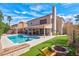 Stunning backyard featuring a pool, spa, covered patio, fire pit and lush landscaping, perfect for entertaining at 37 Stone Cress Dr, Henderson, NV 89074