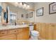 Cozy half-bathroom with wood-paneled wainscoting, framed mirror, and granite countertop at 37 Stone Cress Dr, Henderson, NV 89074