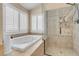 Bathroom with a soaking tub, a shower, and plantation shutters on the window at 37 Stone Cress Dr, Henderson, NV 89074