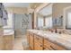 Bathroom featuring granite countertop, double sinks, walk-in shower and a soaking tub at 37 Stone Cress Dr, Henderson, NV 89074