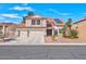 Inviting two-story home features a three-car garage, red tile roof, solar panels, and well-maintained desert landscaping at 37 Stone Cress Dr, Henderson, NV 89074