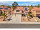 Inviting home boasts a three-car garage, red tile roof, solar panels, and well-maintained desert landscaping at 37 Stone Cress Dr, Henderson, NV 89074