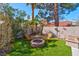 Cozy backyard fire pit area with Adirondack chairs, surrounded by lush landscaping and privacy fencing at 37 Stone Cress Dr, Henderson, NV 89074